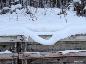An interesting loop of snow hanging precariously off a retaining wall.